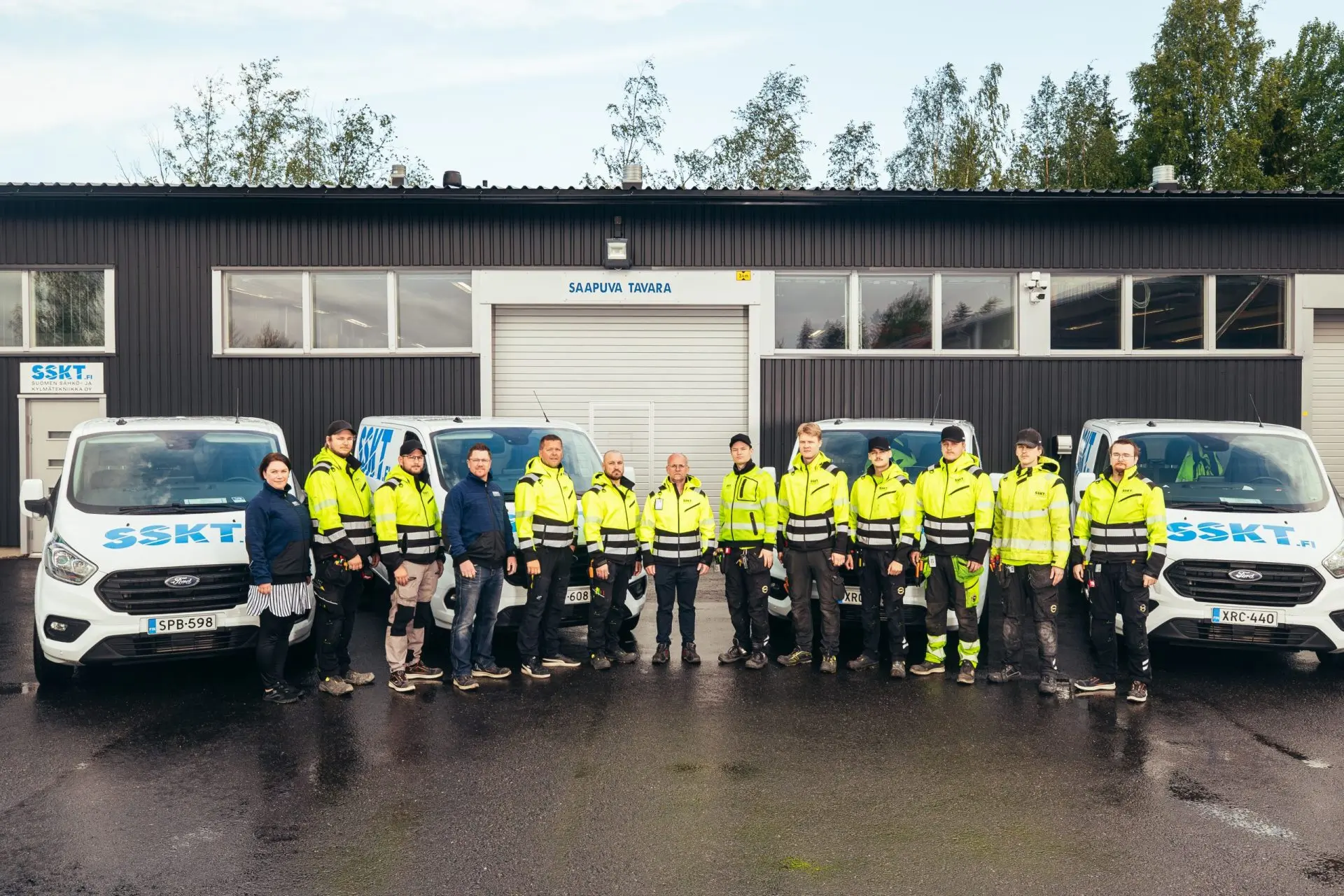 SSKT:n henkilöstöä ja huoltoautoja hallin edessä