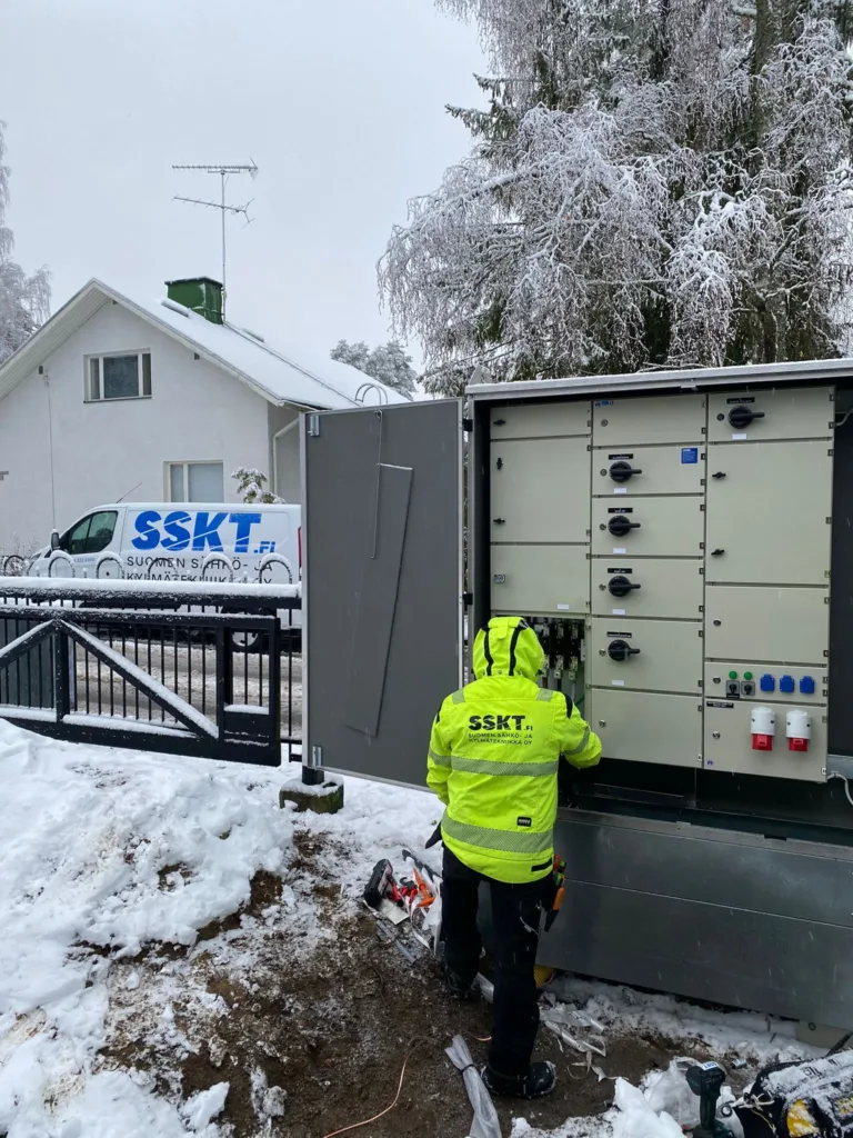 SSKT:n asentaja sähkökeskuksella, taustalla SSKT huoltoauto.